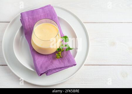 Une boisson fraîche et fraîche à base de lait, de yaourt, d'eau et de mangue sur fond clair. Banque D'Images