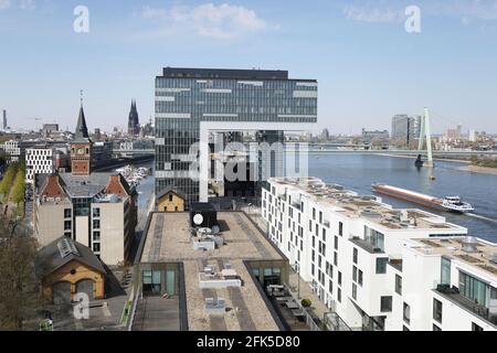 Cologne, Allemagne. 28 avril 2021. Un navire (r) passe le Rheinauhafen avec les grues (M) et la cathédrale (l). Credit: Oliver Berg/dpa/Alay Live News Banque D'Images