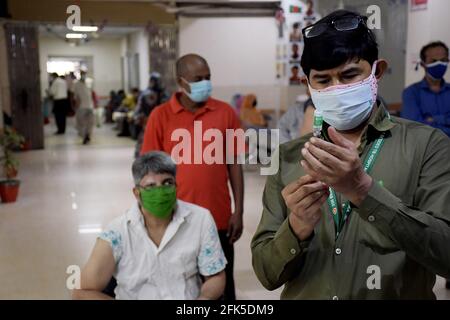Dhaka, Bangladesh. 27 avril 2021. DHAKA, BANGLADESH - avril 28 : un personnel médical inocule un homme avec le vaccin contre le coronavirus Covid-19 à l'hôpital de 250 lits pour la tuberculose alors que la vaccination a commencé dans tout le pays le 28 avril 2021, à Dhaka, au Bangladesh.( Credit: SIPA USA/Alamy Live News Banque D'Images