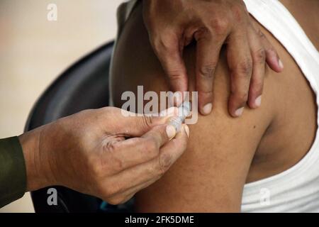 Dhaka, Bangladesh. 27 avril 2021. DHAKA, BANGLADESH - avril 28 : un personnel médical inocule un homme avec le vaccin contre le coronavirus Covid-19 à l'hôpital de 250 lits pour la tuberculose alors que la vaccination a commencé dans tout le pays le 28 avril 2021, à Dhaka, au Bangladesh.( Credit: SIPA USA/Alamy Live News Banque D'Images
