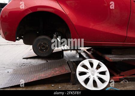 roue démontée de la voiture rouge en cours de réparation Banque D'Images