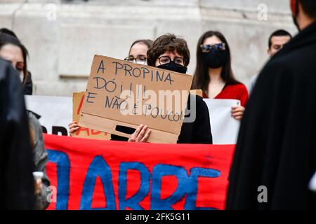 Lisbonne, Portugal. 28 avril 2021. Un étudiant portant un masque de visage tient un écriteau pendant la démonstration.les associations d'étudiants de l'université au Portugal ont appelé à une protestation contre les frais d'école. Selon les leaders étudiants, la "question d'une éducation juste et démocratique" est en jeu. Crédit : SOPA Images Limited/Alamy Live News Banque D'Images