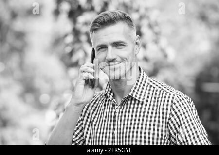 homme d'âge mûr toujours en ligne. concept d'entreprise agile. communication avec des appareils modernes. homme joyeux parle sur téléphone mobile. beau homme d'affaires a Banque D'Images