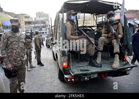Peshawar. 28 avril 2021. Des soldats pakistanais patrouillent dans un marché du nord-ouest du Pakistan à Peshawar le 28 avril 2021. Des troupes de l'armée pakistanaise ont été déployées dans 16 villes du pays pour assurer le respect par le public des directives de la COVID-19. Credit: Saeed Ahmad/Xinhua/Alay Live News Banque D'Images