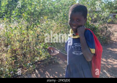 Mzuzu, Malawi. 30-05-2018. Portrait d'une jeune fille noire avec un uniforme d'école souriant à l'appareil photo de retour à la maison dans un village rural au Malawi. Banque D'Images