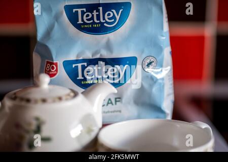 Norwich, Norfolk, Royaume-Uni – avril 28 2021. Gros plan et attention sélective sur les sachets de thé Tetley décaféiné à côté d'une petite tasse de thé et d'une théière. Dep. Intentionnel peu profonde Banque D'Images