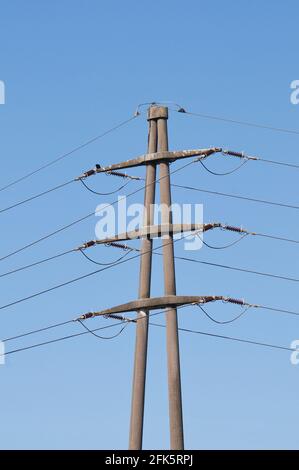 Vue sur une pierre à haute tension de transmission électrique pylône contre Ciel bleu en Suisse Banque D'Images