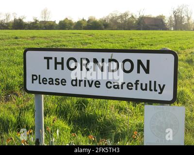 Panneau à l'entrée du village : « THORNDON Veuillez conduire prudemment ». Banque D'Images