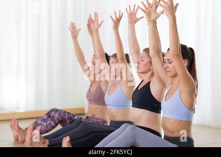Groupe de jeunes femmes sportives attirantes en studio de yoga, pratiquant la leçon de yoga avec instructeur. Banque D'Images