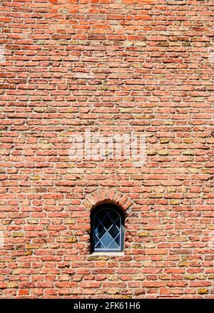 Petite fenêtre dans un mur de briques d'un ancien anglais maison Banque D'Images