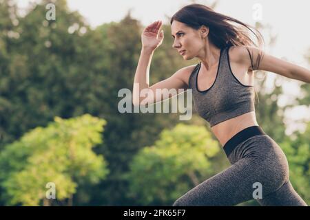 Portrait de profil de charmante jeune femme active courir pressé look loin de là, les courses matinales se garent à l'extérieur Banque D'Images