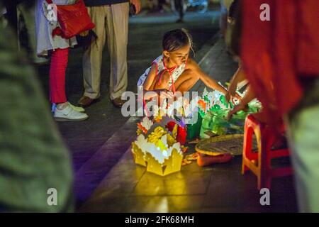 Une jeune fille vietnamienne vend des lanternes flottantes colorées au bord de la rivière, dans la vieille ville, Hoi an, Vietnam Banque D'Images