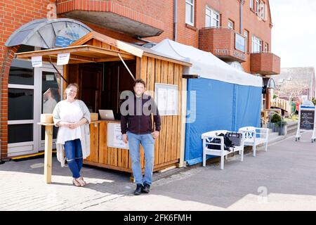 Norddorf, Allemagne. 28 avril 2021. Nicole (l) et Gunnar Hesse, propriétaires de l'hôtel Seeblick on Amrum, se tiennent devant une station d'essai Corona qu'ils ont construite eux-mêmes. Le 1er mai, le projet 'Model Region Kreis Nordfriesland' commence. Ensuite, les hôtes de nuit peuvent être reçus à nouveau sur les îles de la Frise du Nord sous certaines conditions. Credit: Frank Molter/dpa/Alay Live News Banque D'Images