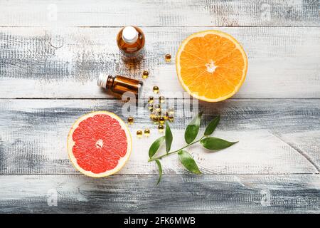Composition avec des pilules de vitamine C et des agrumes sur bois arrière-plan Banque D'Images