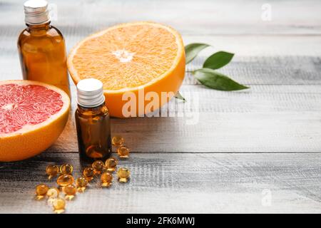 Composition avec des pilules de vitamine C et des agrumes sur bois arrière-plan Banque D'Images