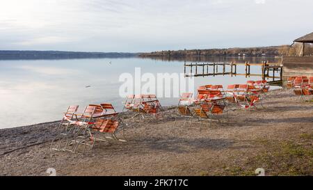 Herrsching, Allemagne - 4 février 2021: Chaises et tables d'un restaurant - fermé avec ruban barrière. Au bord du lac de Herrsching am Ammersee. Banque D'Images