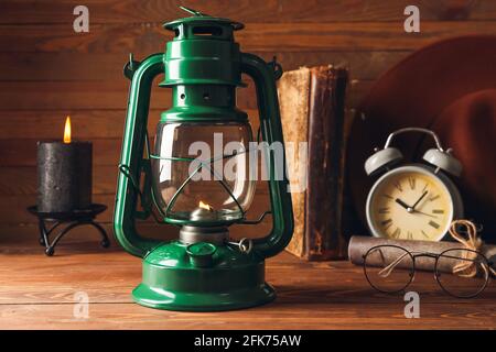 Lampe rétro élégante, réveil et lunettes sur fond de bois Banque D'Images