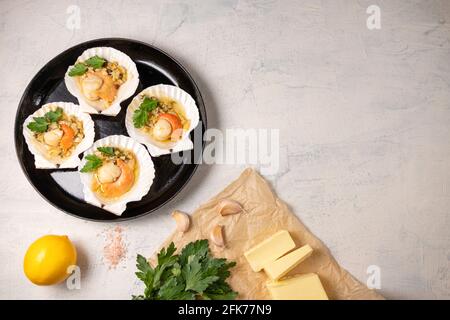 noix de saint-jacques cuites avec caviar et sauce à l'ail crémeuse. Pétoncles, citron, ail, persil, beurre et sel. Recette pour la cuisson de pétoncles avec caviar. Haut vi Banque D'Images