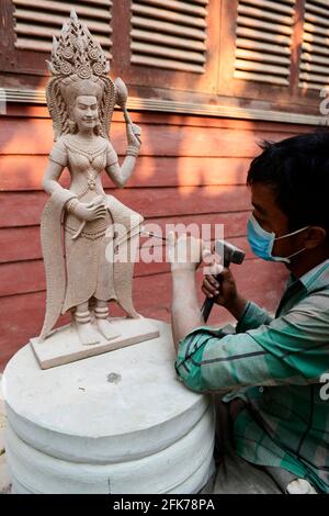 Un sculpturiste khmer travaillant sur sa sculpture d'Apsara à Siem Reap, Cambodge. Banque D'Images