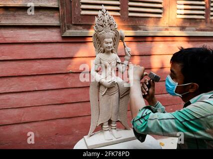 Un sculpturiste khmer travaillant sur sa sculpture d'Apsara à Siem Reap, Cambodge. Banque D'Images