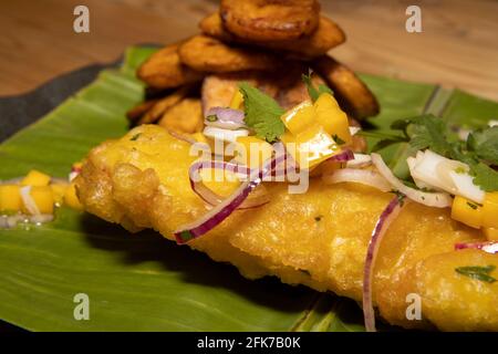 Un délicieux plat de poisson frit et d'inspiration ouest-africaine Frites avec tranches de banane frites servies sur une feuille de banane Banque D'Images