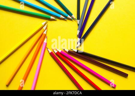 Jeu de crayons colorés sur fond jaune est disposé dans un cercle en forme de carré. CopySpace, cadre. Retour à l'école, artiste, dessin l Banque D'Images