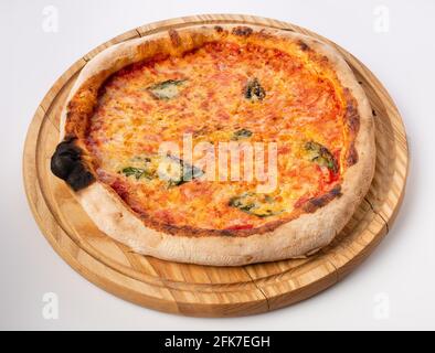 Vue de dessus de pizza chaude sur un stand en bois. Pizza Margarita . Base de tomate et beaucoup de mozzarella, le goût du fromage hollandais et du basilic frais. Banque D'Images