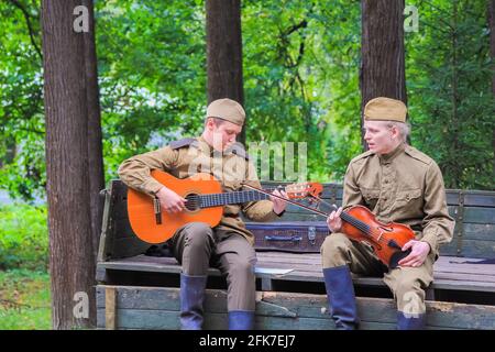 Reconstruction du temps de la Grande guerre patriotique. Les soldats dans la voiture jouent le violon et la guitare à côté du garçon. Moscou Russie septembre 16 Banque D'Images