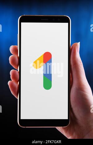 POZNAN, POL - APR 25, 2021: Main tenant smartphone affichant le logo de Google One, un service d'abonnement développé par Google qui offre clo étendu Banque D'Images