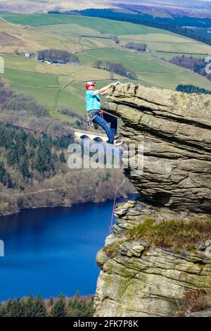 Grimpeur de rochers sur Bamford Edge au-dessus du réservoir Ladybower, Derbyshire, Peak District Banque D'Images