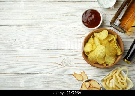 Différentes collations, bières et sauces sur fond de bois blanc Banque D'Images