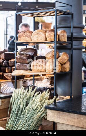 Variété de pain artisanal frais sur une étagère dans la boulangerie. Pains gastronomiques à vendre. Mise au point sélective. Banque D'Images