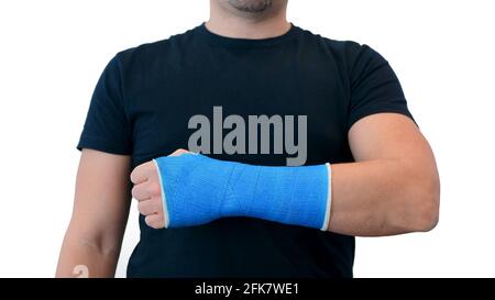 Un homme méconnaissable dans un T-shirt noir montre enveloppé à la main dans un plâtre en fibre de verre moulé sur un fond blanc. Poignet cassé dans un bandage bleu moderne étanche Banque D'Images