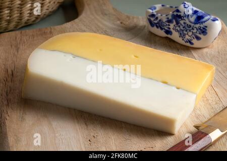 Tranche de fromage double hollandais blanc jaune gros plan à une planche à découper Banque D'Images