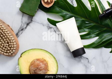 Une belle composition avec de l'huile, du savon écarlate, de l'avocat et des noix. Bouteilles avec produits cosmétiques spa sur fond de palmier, vue du dessus. Salon de beauté Banque D'Images