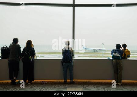 (210429) -- TOKYO, le 29 avril 2021 (Xinhua) -- les gens regardent un avion sur le tarmac à l'aéroport de Haneda au début de la semaine d'or du Japon à Tokyo, au Japon, le 29 avril 2021. Le gouvernement japonais a imposé l'état d'urgence jusqu'en mai 11 à Tokyo, Osaka, Kyoto et Hyogo, qui vise à limiter une augmentation des cas de COVID-19 pendant les fêtes de la semaine d'or. (Photo de Christopher Jue/Xinhua) Banque D'Images