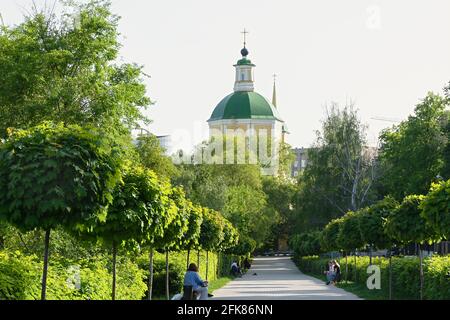 Voronezh Russie 08 mai 2019. Le dôme de l'église de la Résurrection, sur la rue Ordzhonikidze, au milieu des arbres verts de l'allée piétonne. Les gens se détendent Banque D'Images