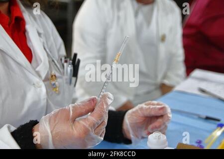 Infirmière à l'intérieur de la pharmacie tout en préparant une seringue pour l'administration du vaccin pfizer-biontech.pharmacie mise en place dans une salle de Real Bosco . Banque D'Images