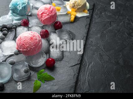Glace aux baies et aux fruits sur glace sur fond noir avec espace à copier. Banque D'Images