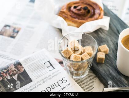 Petit déjeuner minimaliste / style scandinave. Parquet blanc, sucre, café et pain danois. Banque D'Images