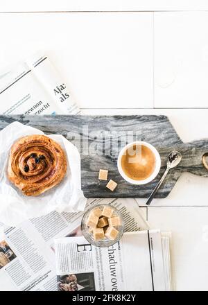 Petit déjeuner minimaliste / style scandinave. Parquet blanc, sucre, café et pain danois. Banque D'Images