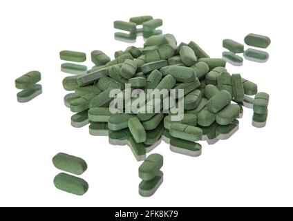 Pilules vertes isolées sur fond blanc. Spiruline. Banque D'Images