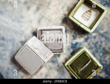 Boîtes à anneaux de mariage en gris et vert, dans un plat. Banque D'Images