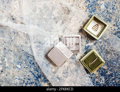 Boîtes à anneaux de mariage en gris et vert, dans un plat. Banque D'Images