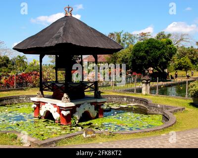 Une petite pagode, kiosque dans un réservoir plein de charmants lilpads. Au palais de l'eau de Tirta Gangga à Bali, en Indonésie. Banque D'Images