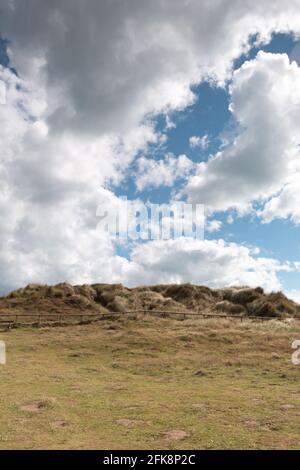 Un knoll herbeux sur la côte sud de l'Angleterre avec un ciel bleu et une couverture spectaculaire de nuages Banque D'Images