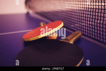 Deux raquettes et balles de tennis de table ou de ping-pong une table bleue avec filet Banque D'Images