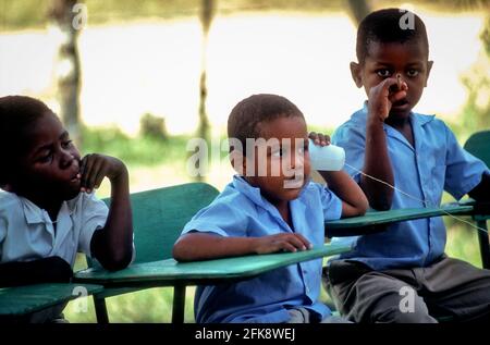 Dominikanische Republik, Schulkinder einer Freiluftschule in Cruz Verde spielen Telefonieren. Banque D'Images