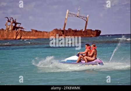 Dominikanische Republik, Wassermoped mit Urlaubern und Schiffrack, vor der Kueste von Punta Cana. Banque D'Images