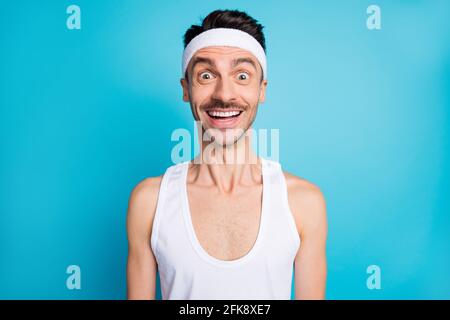 Portrait d'un homme sportif impressionné, la bouche ouverte, le cri s'use en blanc débardeur unique isolé sur fond bleu Banque D'Images